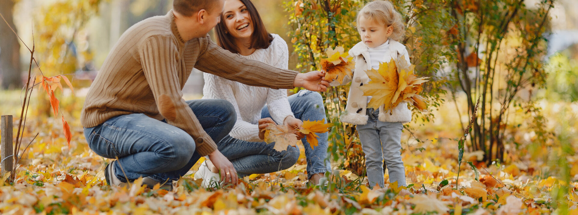 A family gathering autumn leaves together outdoors in Windsor